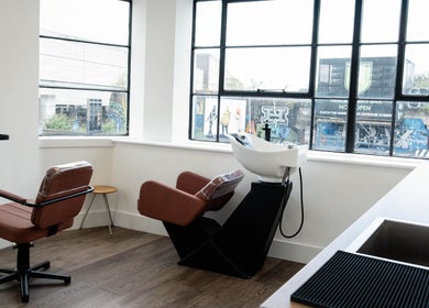 Stylish interior of Logvina Hair in London, England, GB showcasing modern salon chairs and washing station.