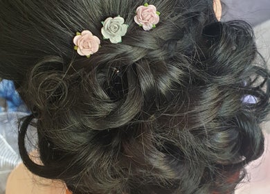 Intricate braided updo with floral accents at Hair By Claire, Harwich, England, GB.