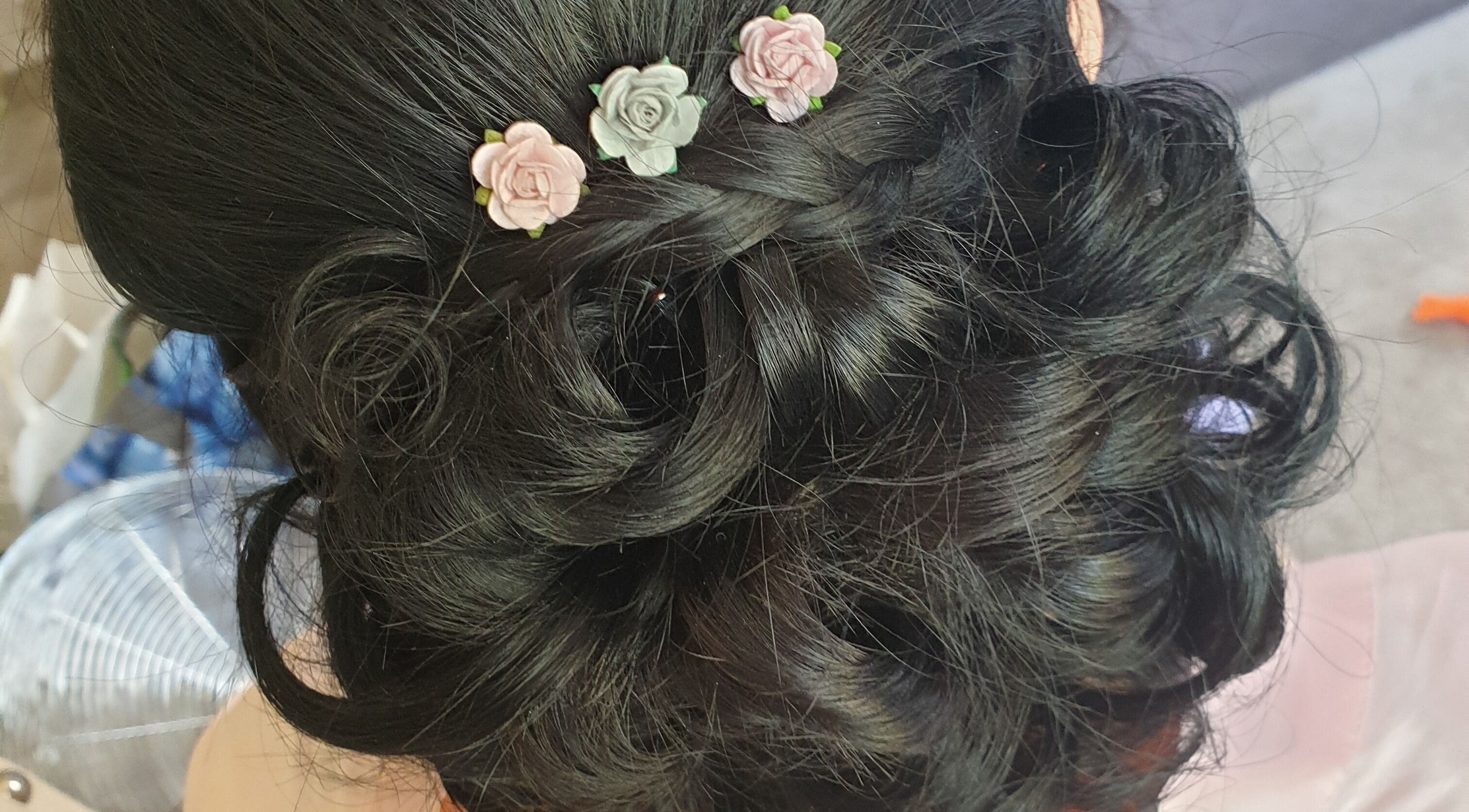 Intricate braided updo with floral accents at Hair By Claire, Harwich, England, GB.