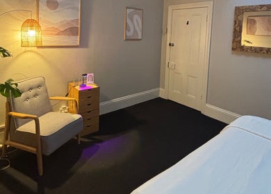 Cozy interior of Choojai Thai Massage, Richmond, Victoria, AU, featuring warm lighting and a relaxing armchair.