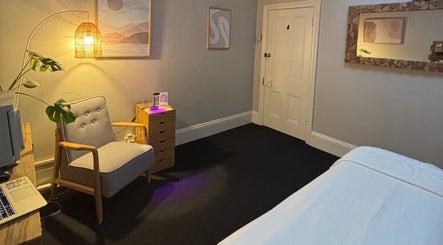 Cozy interior of Choojai Thai Massage, Richmond, Victoria, AU, featuring warm lighting and a relaxing armchair.