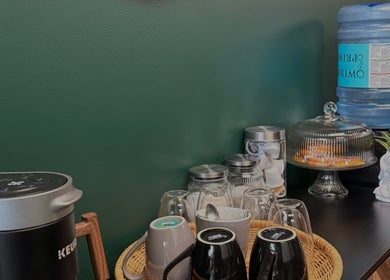 Refreshment station at Elegant Aesthetics, Calgary, Alberta, CA, with coffee maker and treats.