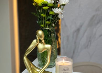 Escultura dorada con flores y vela en Dubíe Studio, Santiago, Región Metropolitana, CL.