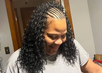 Smiling person showcasing intricate braids at Crownedbyexperience in Chicago, Illinois, US.