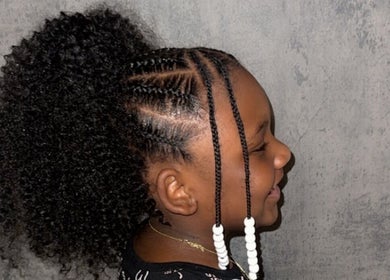 Child with beautiful braided hair and beads at Crownedbyexperience, Chicago, Illinois, US.