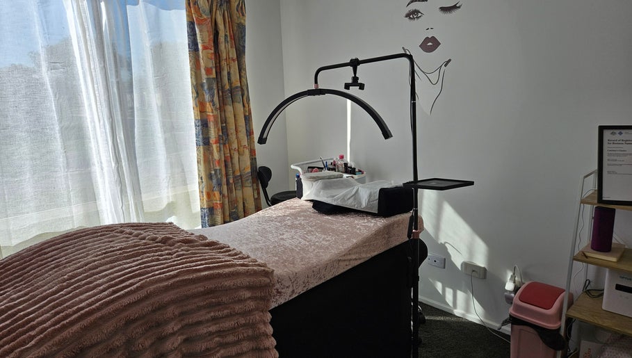 Bright treatment room at Courtney's Classics, Melbourne, Victoria, AU, with cozy bed and wall art.