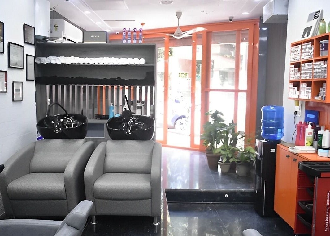 Modern interior of The Specialist Unisex Salon in New Delhi, showcasing chic gray seating and stylish décor.