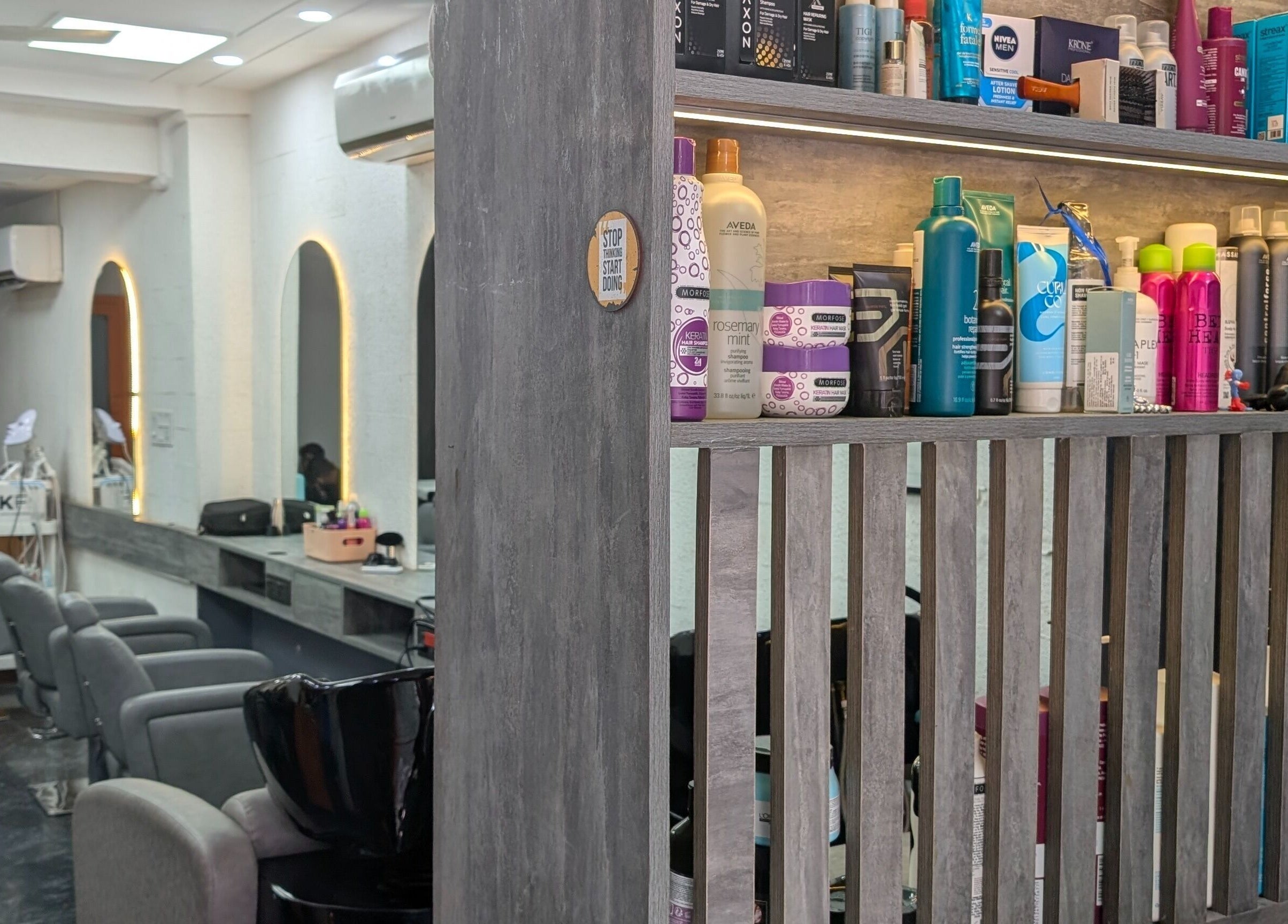 Interior view of The Specialist Unisex Salon in New Delhi, Delhi, IN, showcasing product shelves and comfortable chairs.