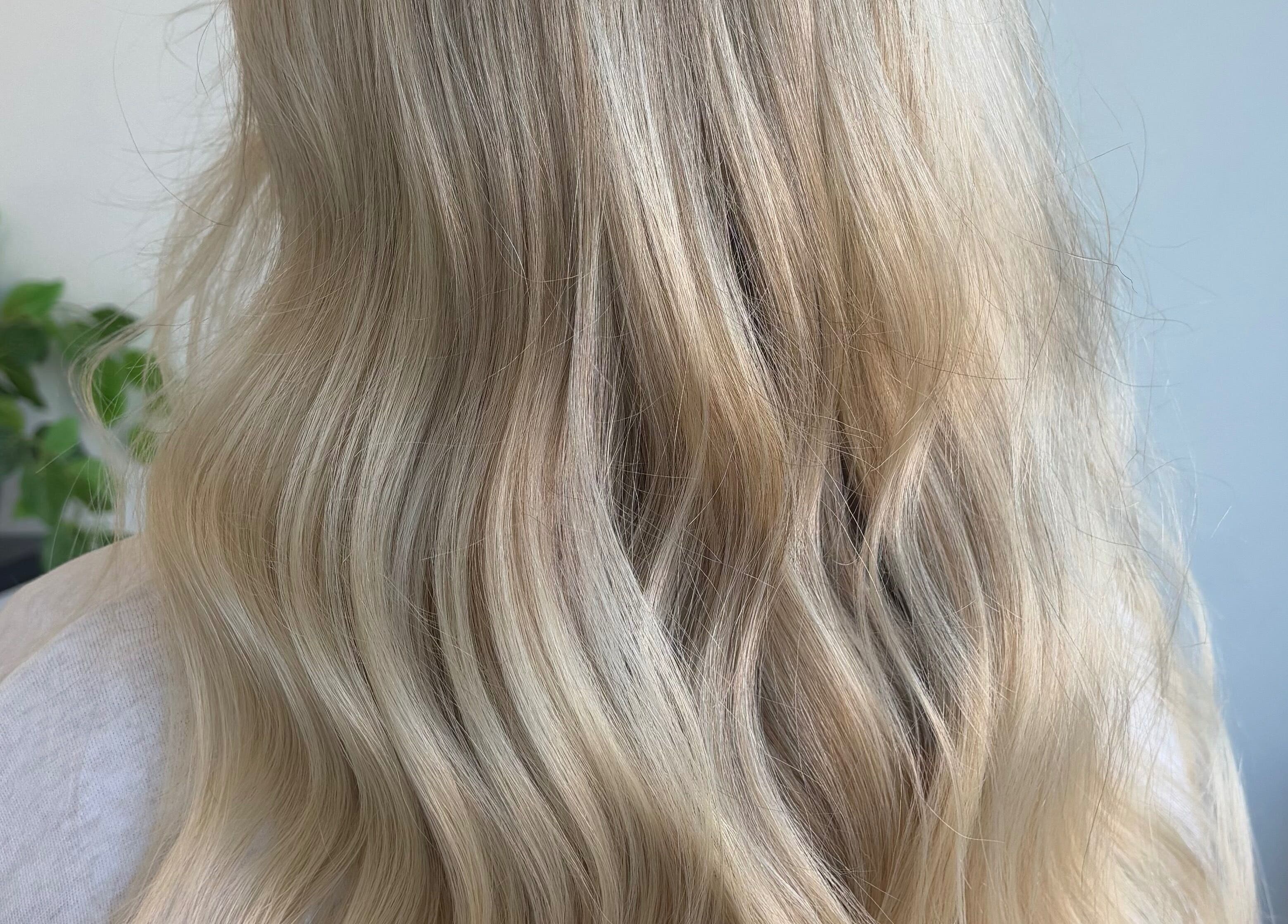 Beautiful blonde waves styled at Hair by Emma Sturt in Beenleigh, Queensland, AU with plants in the background.
