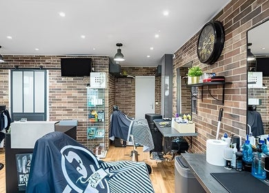 Salon moderne chez 223 The chirurgien, Paris, Île-de-france, FR, avec murs en briques et fauteuils élégants.