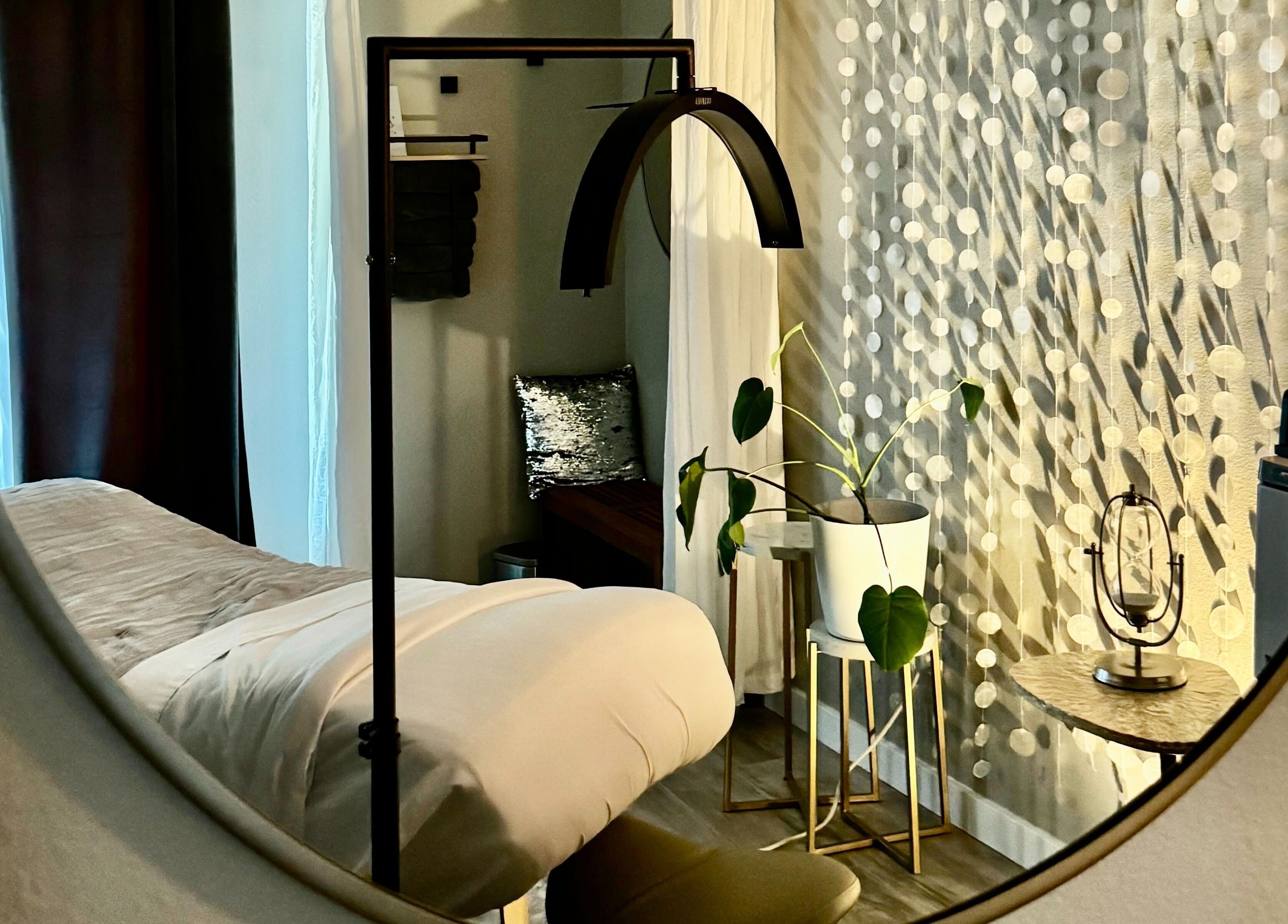 Elegant treatment room at Essential Luxuries Day Spa, Snohomish, Washington, US, with plush bed and decor.