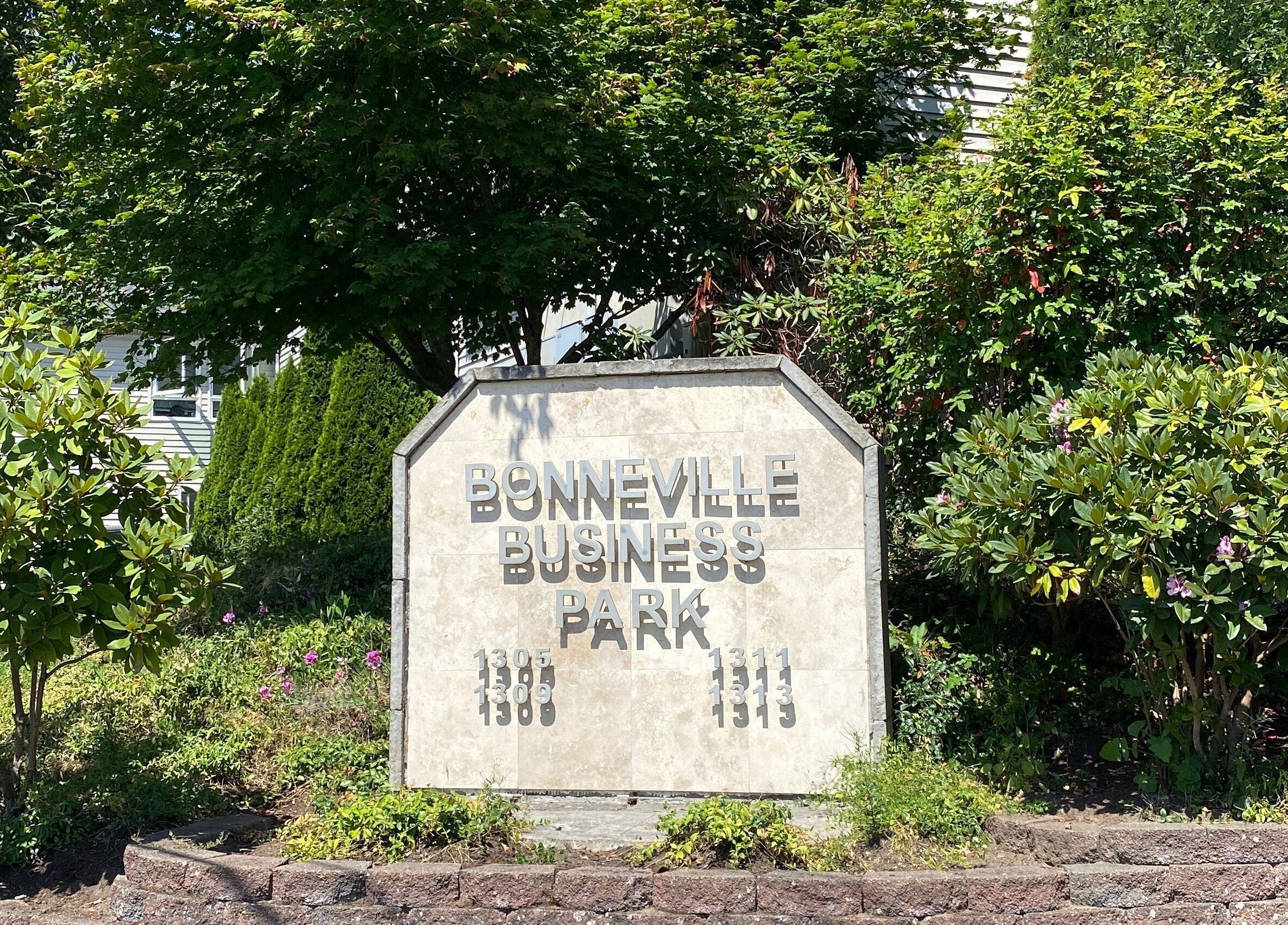 Entrance sign at Essential Luxuries Day Spa, Snohomish, Washington, US, surrounded by lush greenery.