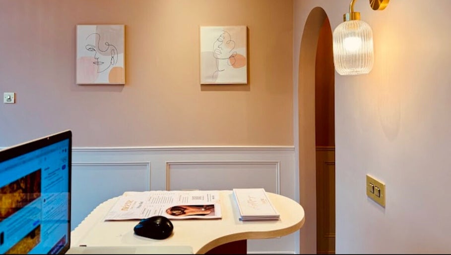 Stylish reception at LuxeLoxx by Chloe, Glasgow, GB. Modern decor with soft lighting and artistic wall art.