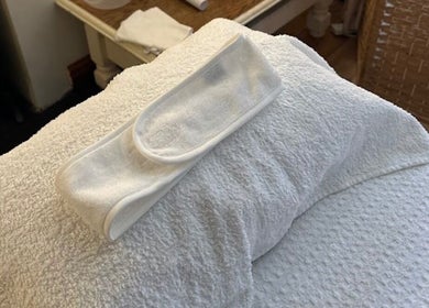 Relaxing treatment setup at Godalming Skin Co. in Godalming, England, GB, featuring a towel and headband.