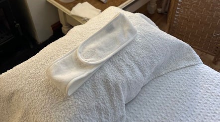 Relaxing treatment setup at Godalming Skin Co. in Godalming, England, GB, featuring a towel and headband.