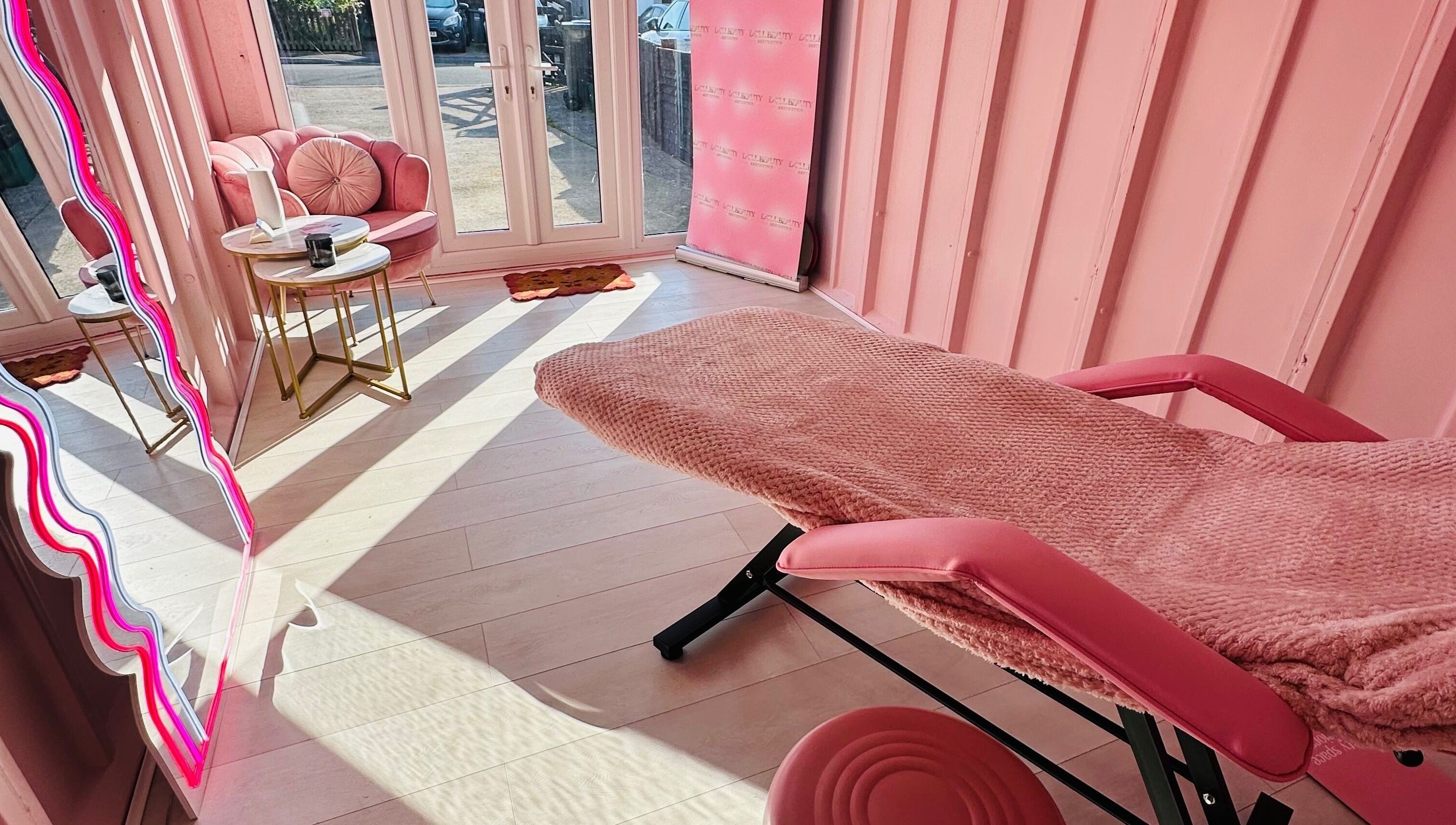 Relaxing treatment space at Doll Beauty Aesthetics & Training Academy, Cleeve, England, GB with pink decor.