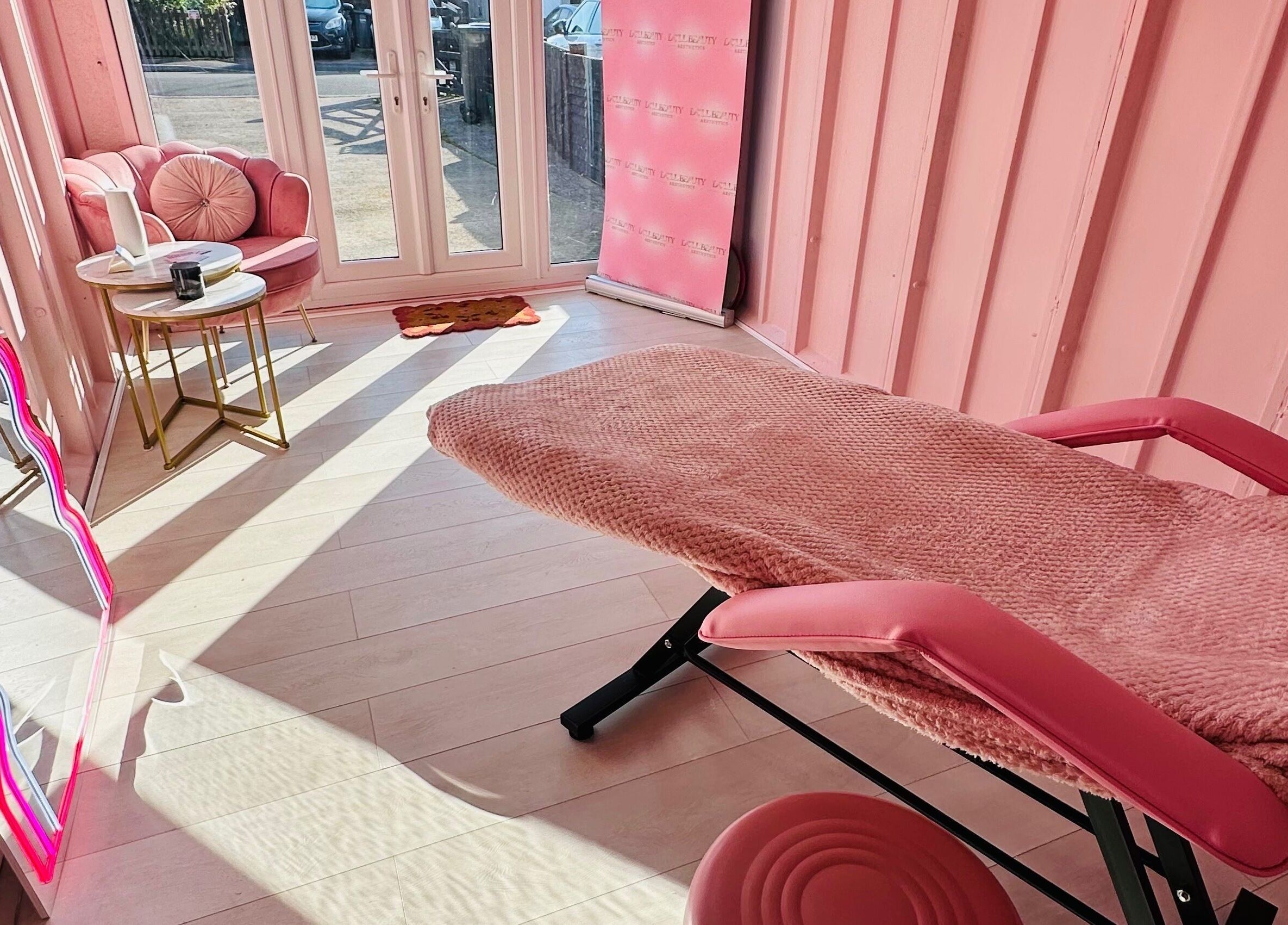 Relaxing treatment space at Doll Beauty Aesthetics & Training Academy, Cleeve, England, GB with pink decor.