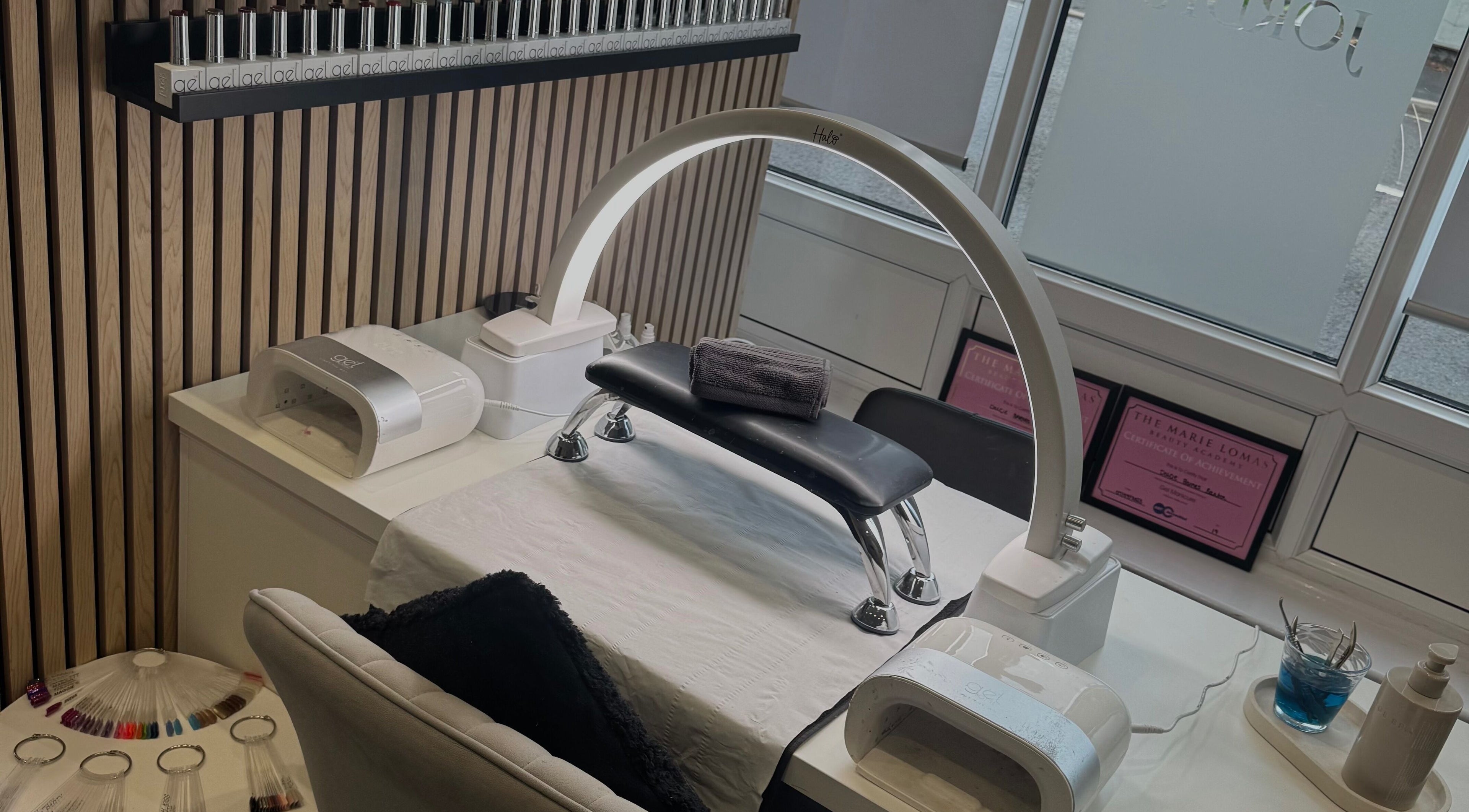 Nail station at Dolly’s Beauty Bar, Newhall, England, GB featuring gel polishes and modern manicure equipment.