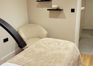 Serene spa room at Naked Beauty in North Weald Bassett, England, GB, with plush bedding and modern decor.