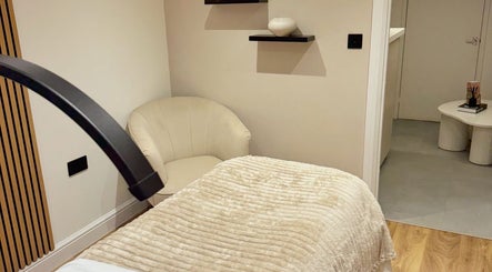 Serene spa room at Naked Beauty in North Weald Bassett, England, GB, with plush bedding and modern decor.