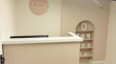 Reception area of Naked Beauty in North Weald Bassett, England, GB with elegant decor and product display.