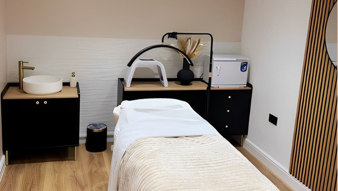 Modern treatment room at Naked Beauty in North Weald Bassett, GB, featuring sleek decor and a comfortable massage bed.