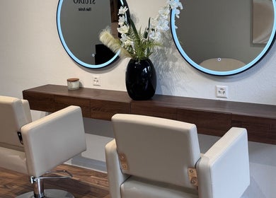 Intérieur moderne de MC Studio Hair Artist à Lausanne, Vaud, CH avec miroirs et fauteuils.