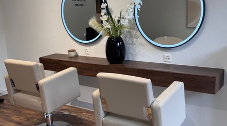Intérieur moderne de MC Studio Hair Artist à Lausanne, Vaud, CH avec miroirs et fauteuils.
