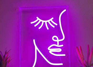 Purple neon face art at NC Beauty Bar, LLC, Milwaukee, Wisconsin, US, creating a chic ambiance.