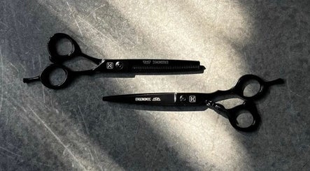 Black ergonomic barber shears at Nicco the Barber, Kansas City, Missouri, US, enhancing styling precision.
