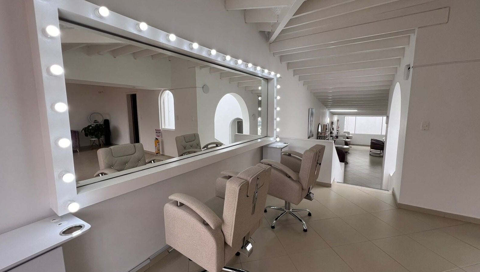 Interior elegante de ROSIE BEAUTY STUDIO en Bogotá, D.c., Bogotá, D.c., CO con espejos y sillas modernas.