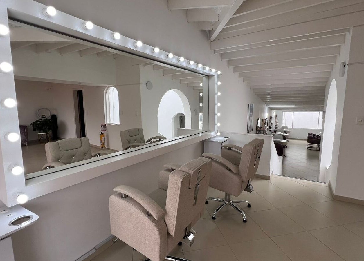 Interior elegante de ROSIE BEAUTY STUDIO en Bogotá, D.c., Bogotá, D.c., CO con espejos y sillas modernas.