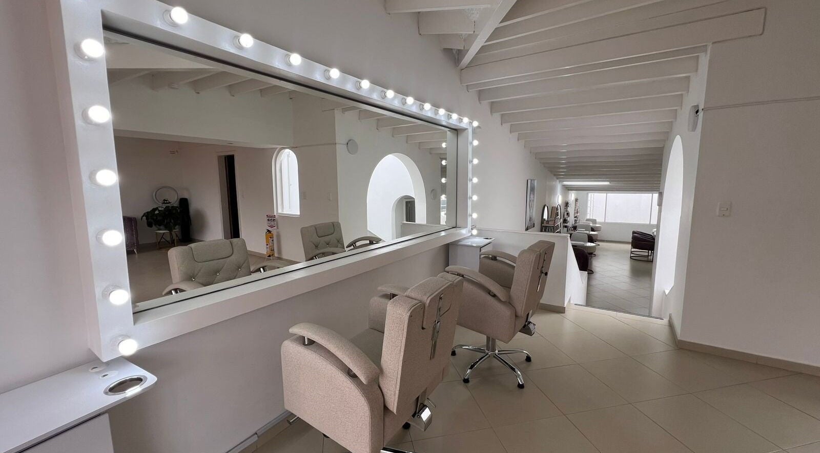 Interior elegante de ROSIE BEAUTY STUDIO en Bogotá, D.c., Bogotá, D.c., CO con espejos y sillas modernas.