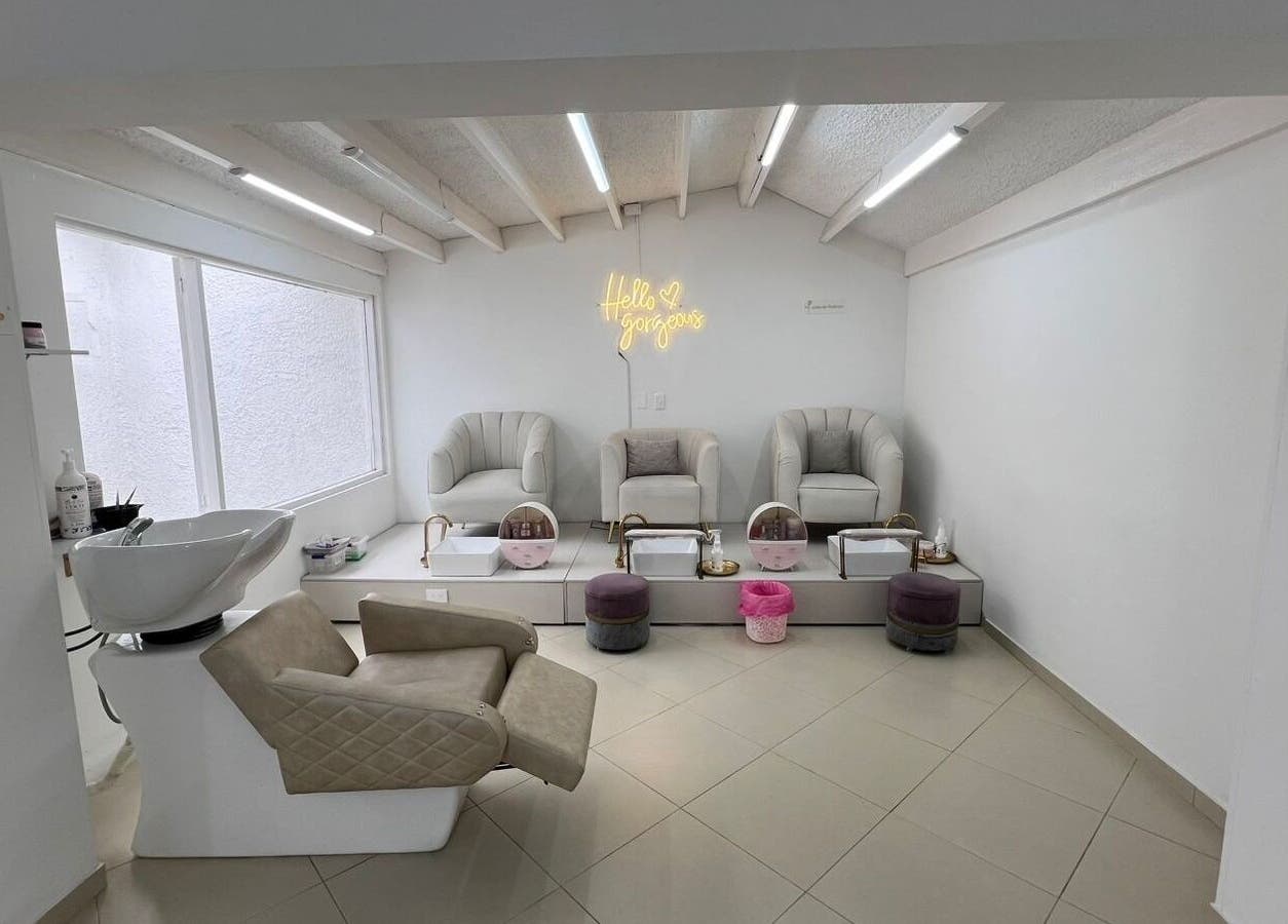 Área de manicura en ROSIE BEAUTY STUDIO, Bogotá, D.c., con sillones y iluminación acogedora.