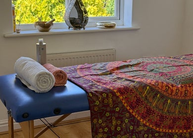 Massage table at Healing Hands, Spalding, England, GB adorned with colorful linen and neatly folded towels.