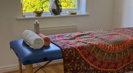Massage table at Healing Hands, Spalding, England, GB adorned with colorful linen and neatly folded towels.