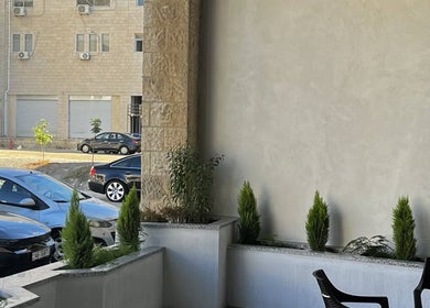 المساحة الخارجية الأنيقة لصالون النحات في عمان، محافظة عمان، JO مع كراسي ونباتات.