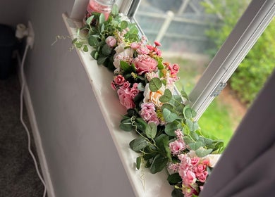 Elegant floral arrangement in window at Dolled by D.X, Rotherham, England, GB, enhancing the serene ambiance.