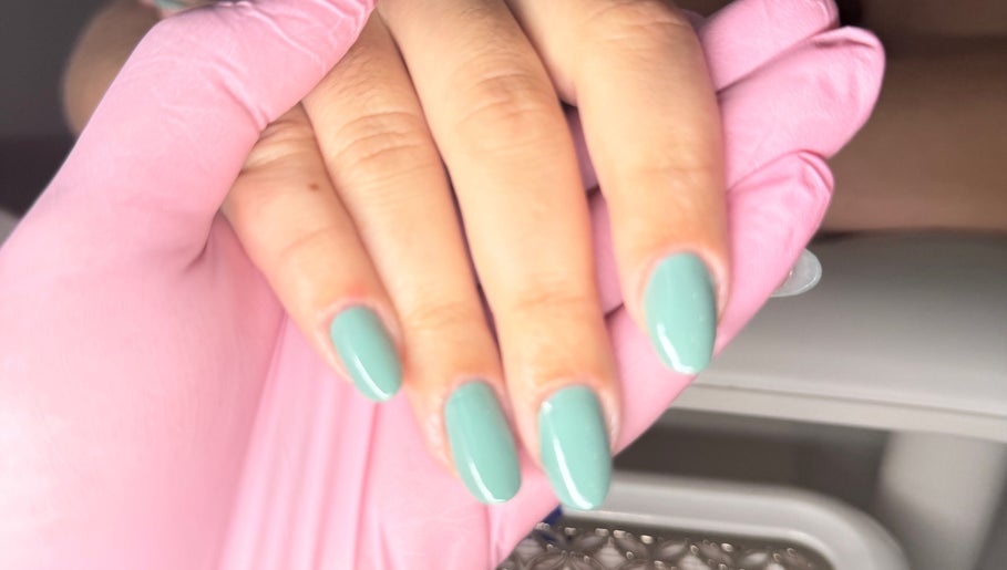 Mint green nails manicure at Nails By Joy, Winter Garden, Florida, US with a stylist wearing pink gloves.