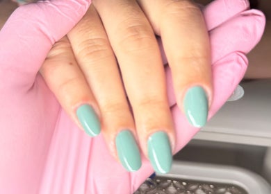 Mint green nails manicure at Nails By Joy, Winter Garden, Florida, US with a stylist wearing pink gloves.