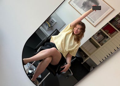 A joyful client in Danielle Frances Hair, Toronto, Ontario, CA, capturing a selfie in a salon chair.