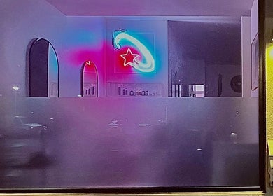 Vibrant neon star at Danielle Frances Hair in Toronto, Ontario, CA, seen through the salon's modern window.