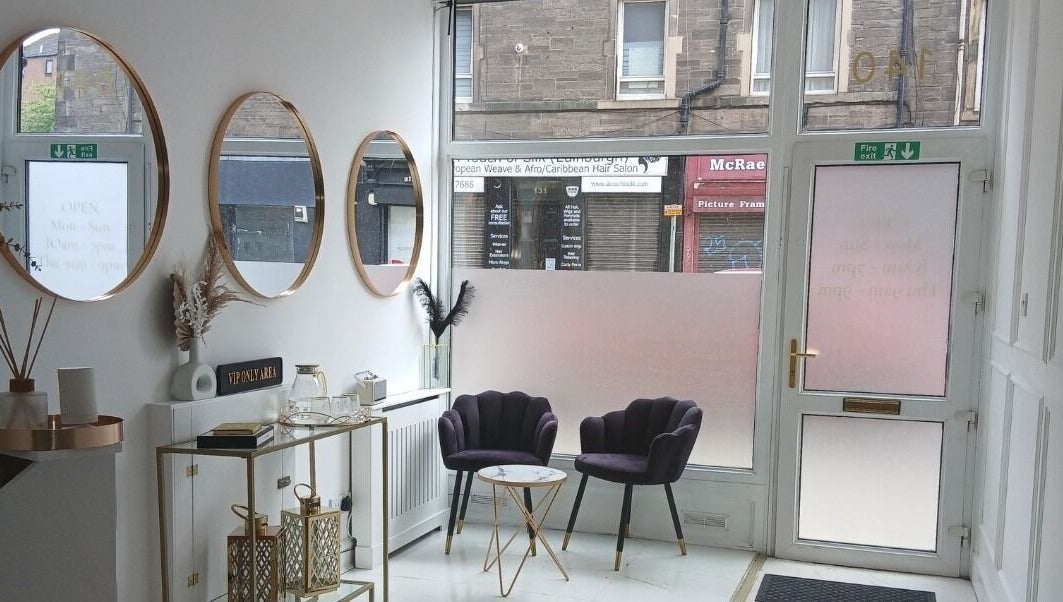 Elegant lounge area at InnerGlow Aesthetics, Edinburgh, Scotland, GB with stylish chairs and mirrors.