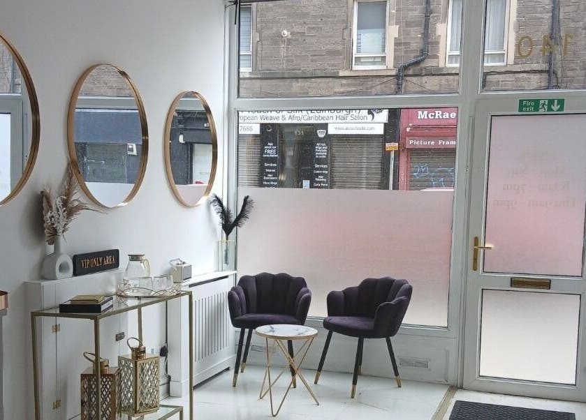 Elegant lounge area at InnerGlow Aesthetics, Edinburgh, Scotland, GB with stylish chairs and mirrors.