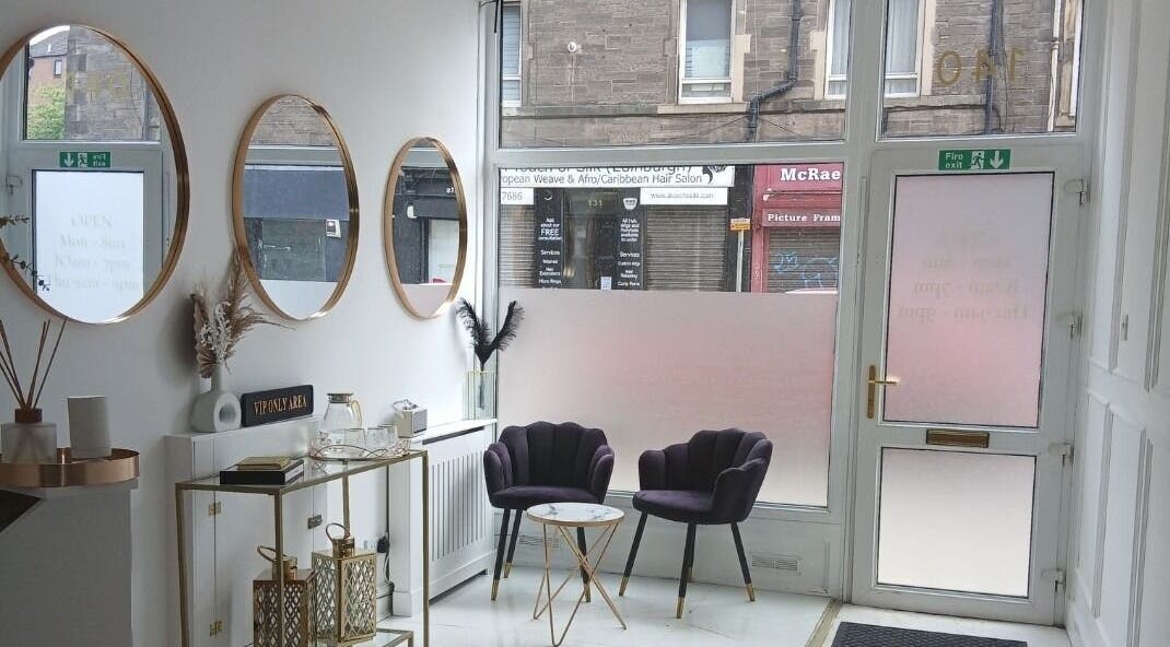 Elegant lounge area at InnerGlow Aesthetics, Edinburgh, Scotland, GB with stylish chairs and mirrors.
