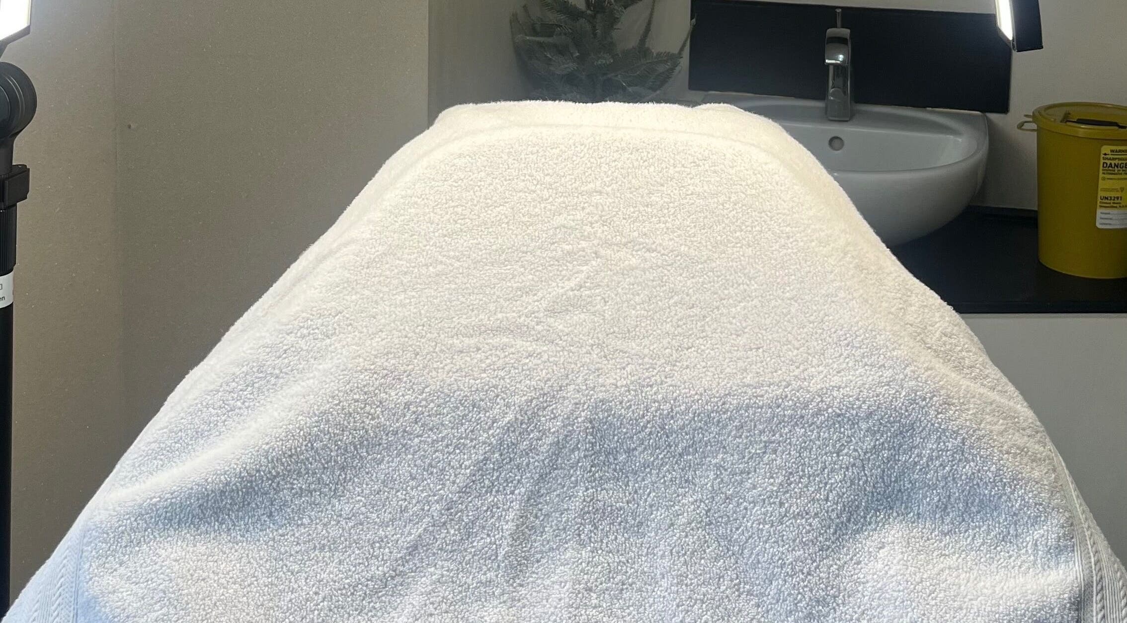 Relaxing treatment room at NV at the Penthouse, Ormskirk, England, GB. Cozy setting with white towel and sink.