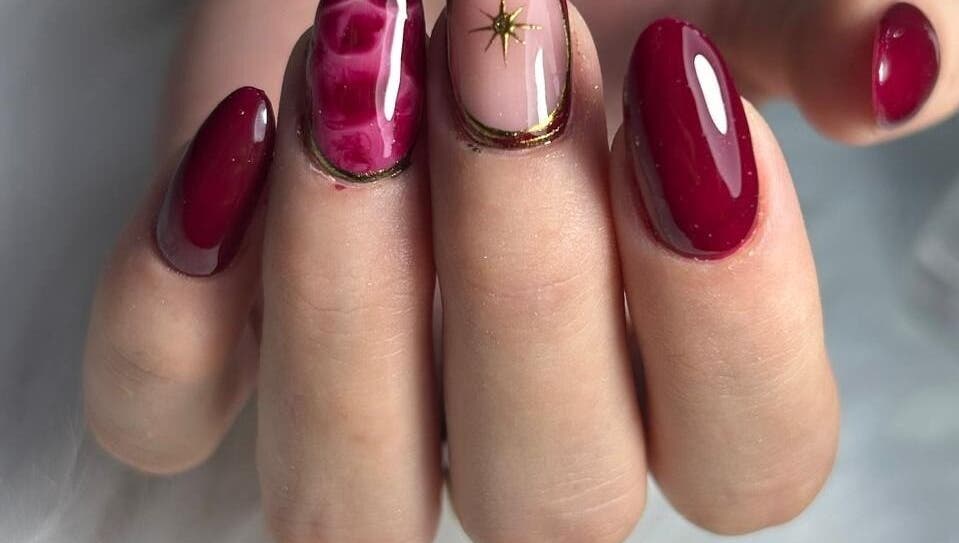 Manicura artística en salón Wumman, San Miguel, Provincia De Lima, PE. Diseño de uñas rojo y dorado.