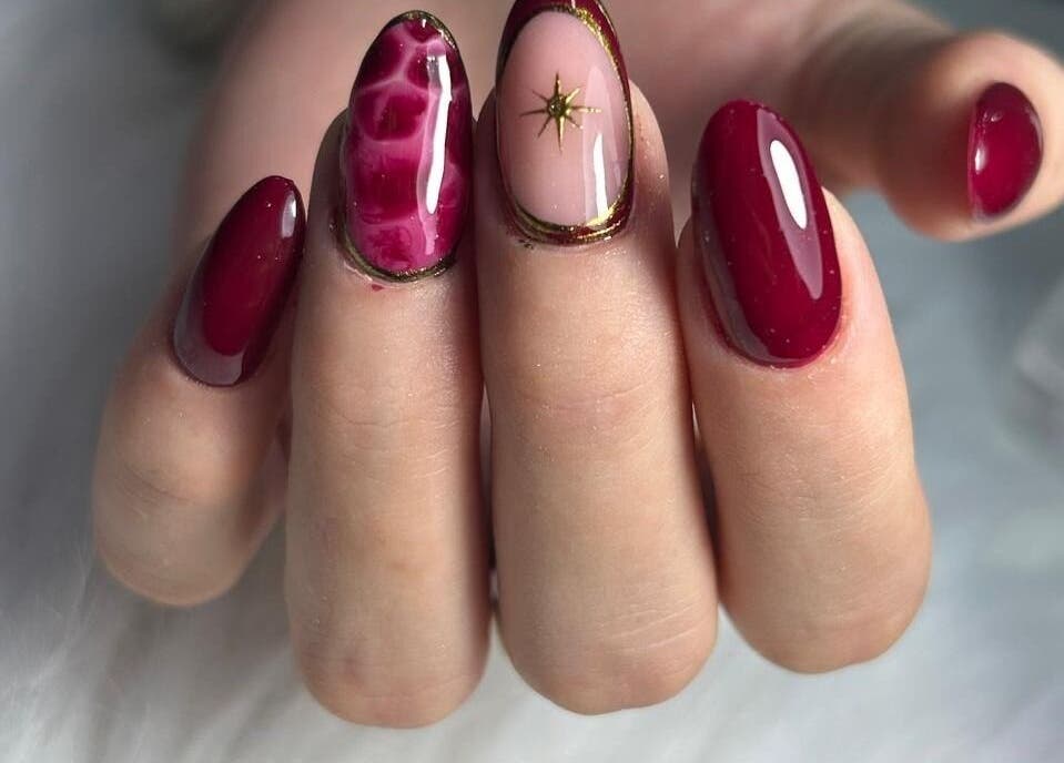 Manicura artística en salón Wumman, San Miguel, Provincia De Lima, PE. Diseño de uñas rojo y dorado.