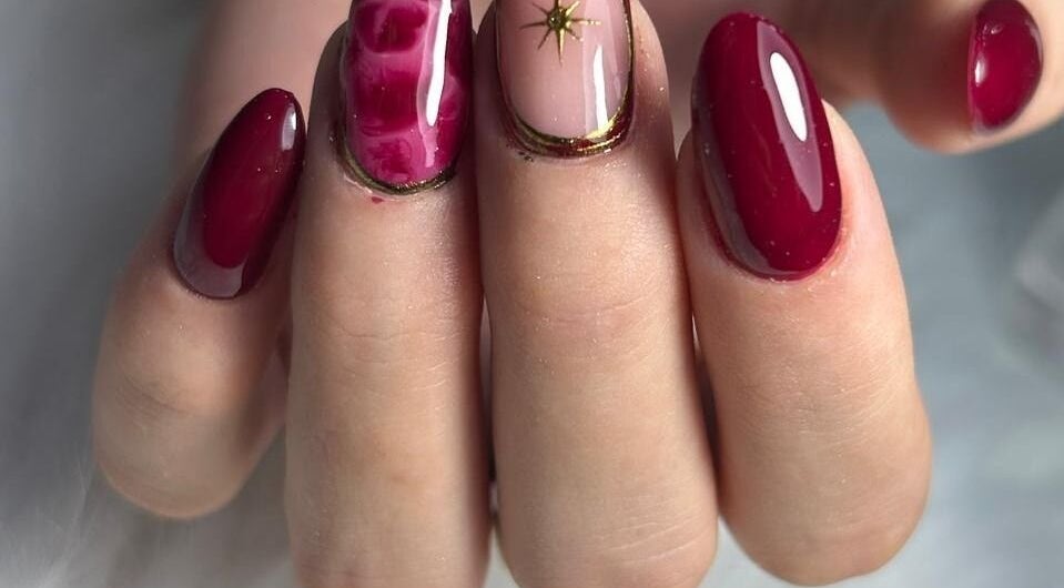 Manicura artística en salón Wumman, San Miguel, Provincia De Lima, PE. Diseño de uñas rojo y dorado.