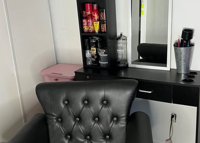 Chic styling station at Kluvv_hairbar, Toronto, Ontario, CA, featuring a black leather chair and grooming tools.
